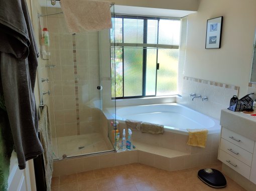 Picture of bathroom showing shower with a hob and large corner bath and step